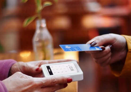 Photo by Nathana Rebouças two people exchanging a credit card at a table